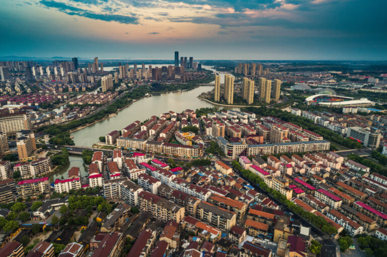 Aerial view of a river winding through a city and its surrounding neighbourhoods