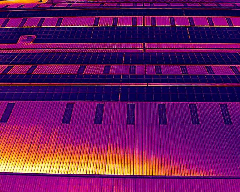 Aerial thermal image of solar panel rows on a commercial roof